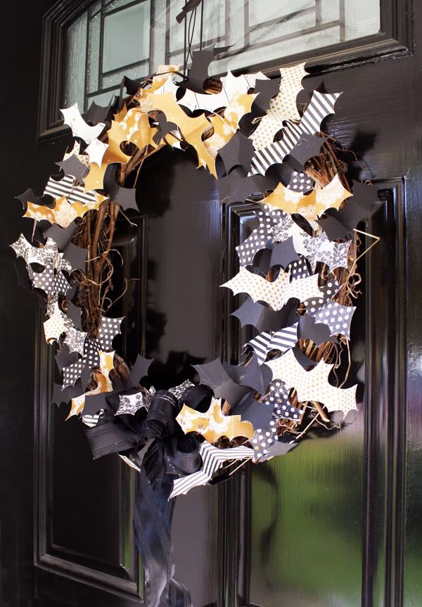 a Halloween wreath of vine covered with black, orange and white paper bats all over is a lovely idea that can be easily DIYed