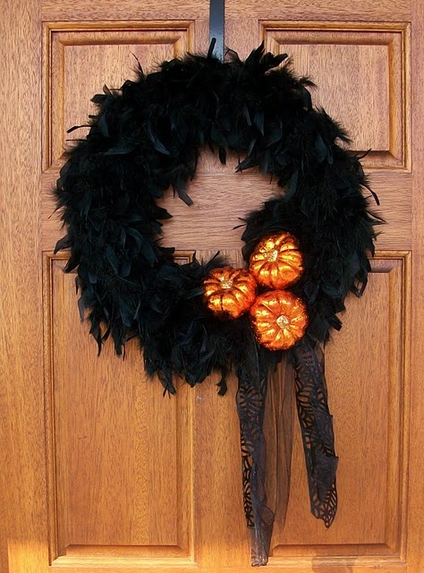 a black feather Halloween wreath accented with orange pumpkins and lace ribbons is a lovely idea for Halloween