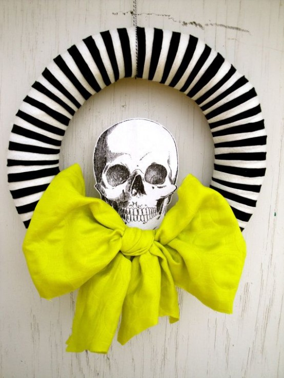 a modern Halloween wreath with a striped form, a neon green bow and a printed skull is a lovely and easy to DIY idea