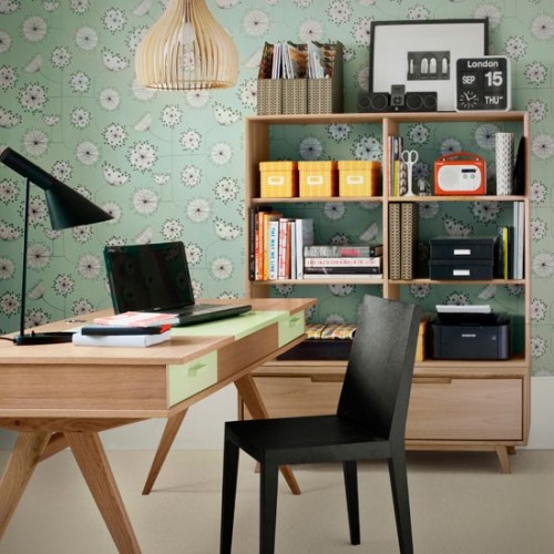 a home office with green floral wallpaper, a stained desk and a black chair, a large bookcase with an additional cabinet is a cool space