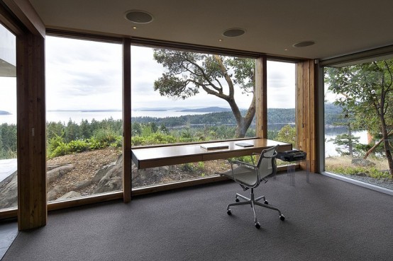 a gorgeous home office with glass walls that allow you enjoying all the views, a floating desk and a chair - you won't need more in this amazing space