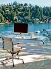 a jaw-dropping home office with a glazed wall that allows to enjoy a gorgeous lake view, an acrylic desk, a comfy chair – you won’t need more