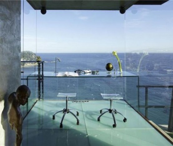 a jaw-dropping glass home office with a glass desk, acrylic chairs and amazing sea views - nothing distracts here from them