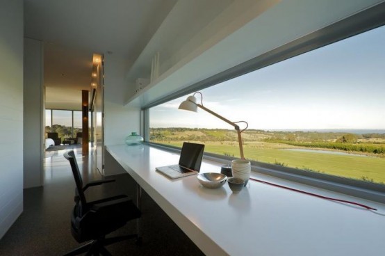 a minimalist home office in white, with a windowsill desk, a chair and a long and narrow window with a fantastic view of the fields that is very relaxing