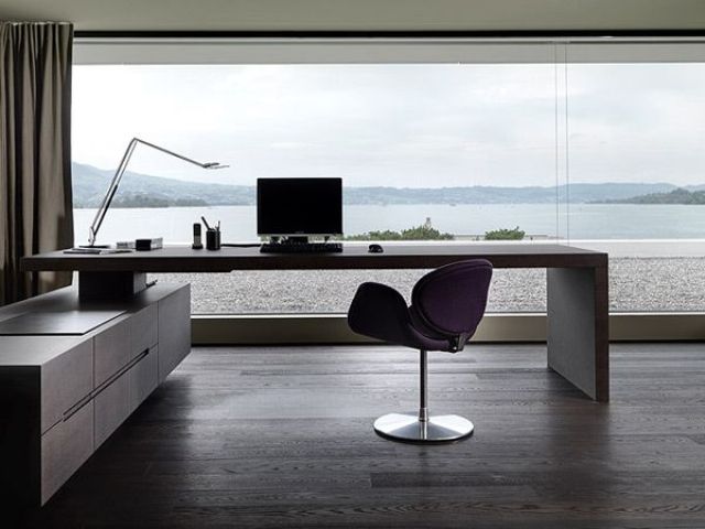 a modern home office with a glazed wall and a sea view that is very peaceful, a built in desk and a chair, a storage unit is a lovely space for working