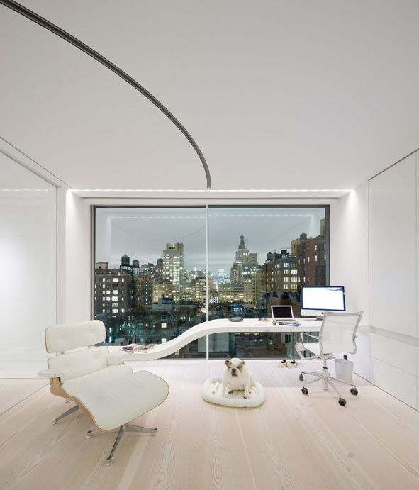 a creamy home office with a glazed wall, a whimsical desk, some creamy chairs and a dog bed plus a big city view