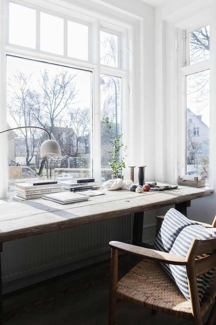 a Scandinavian home office with large windows, views of the neighborhood, a desk and a comfy chair is a lovely space for everything