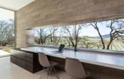 a modern neutral home office with an accent wall, a long and narrow window to enjoy the views and a long shared desk plus a couple of chairs