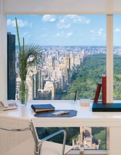 a modern white home office with a glazed wall and a view of the big city, a white desk and a chair is a gorgeous space to work