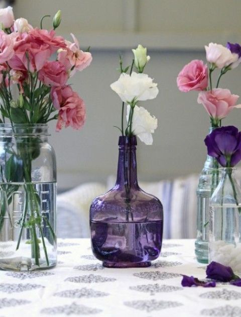 light blue and purple vintage bottles with white, pink and purple blooms can act as centerpieces or just decor, they will be beautiful vases