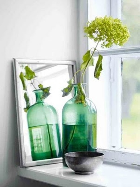 a vintage green bottle as a vase for a green bloom is a cool idea to add a bit of color and natural beauty to your space