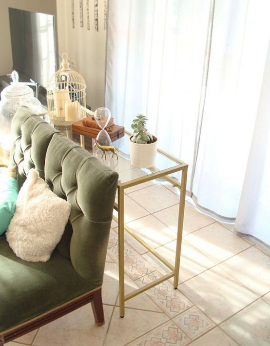 a gold Vittsjo table used as a console table, with a cage, potted plants and some other decor is a stylsih and cool idea