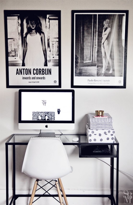 a small black and white working space with an IKEA Vittsjo table, a white chair and black and white artworks over it