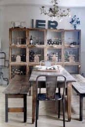 an industrial shabby chic dining room with a shabby wood storage unit, a reclaimed wood dining table and benches, a metal chair and a chic vintage chandelier for an unexpected touch