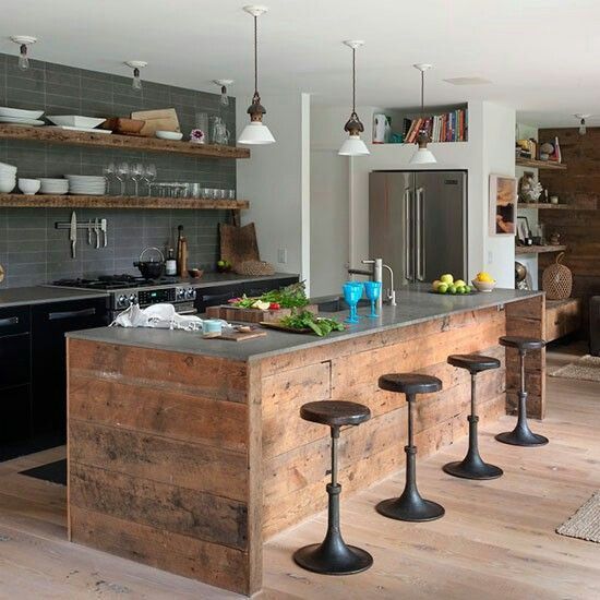 a chic industrial kitchen with black cabinetry and a grey skinny tile backsplash, a reclaimed wood kitchen island and metal stools plus pendant lamps