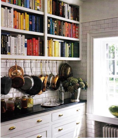 a large bookshelf with additional hooks for pans and pots is great for those who love reading while cooking or eating