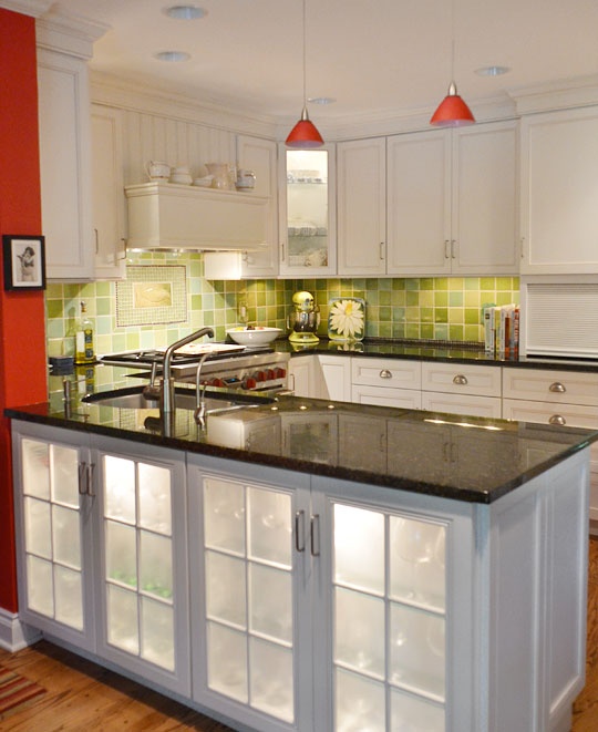 a large kitchen island with storage space and built-in lights plus fridges for storing wine and other alcohol