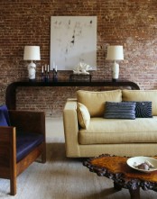 a catchy living room with a red brick statement wall that makes a luxurious space more casual