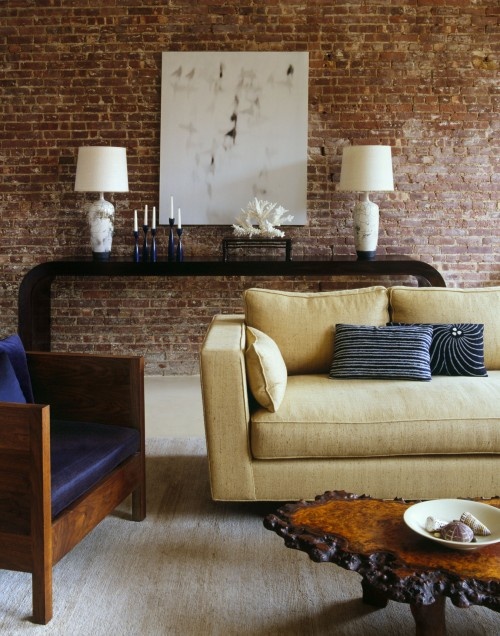 a catchy living room with a red brick statement wall that makes a luxurious space more casual