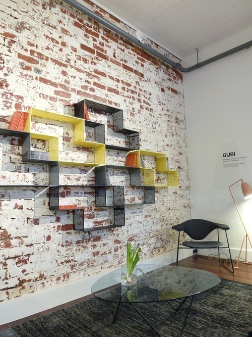 a contemporary living room with a whitewashed red brick wall for a nonchalant feel and a modern shelf on it