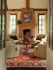 a traditional living room done with a fireplace of red brick for maximal coziness and a vintage feel