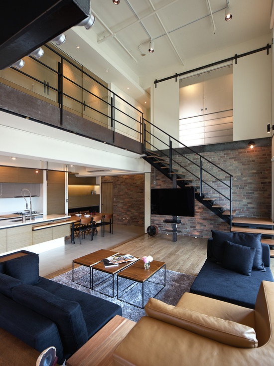 an open layout with a kitchen and living room plus a brick statement wall in muted shades that contrasts white surfaces