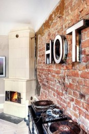 a statement red brick wall with modenr letters and a large stove for more contrast