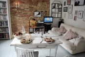 a neutral eclectic space done with a red brick statement wall that adds color to it