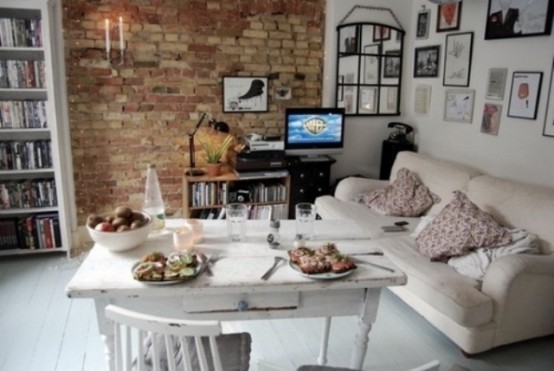 a neutral eclectic space done with a red brick statement wall that adds color to it