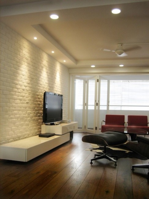 a minimalist living room in black, white and red and with white brick walls for a texture