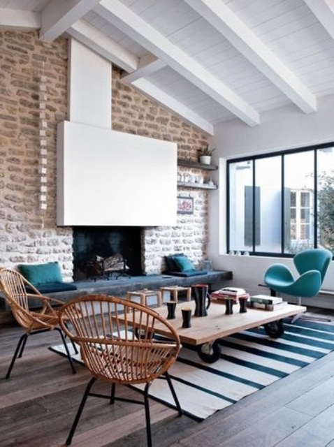 a contemporary living room with a whitewashed statement brick wall, bright and rattan furniture