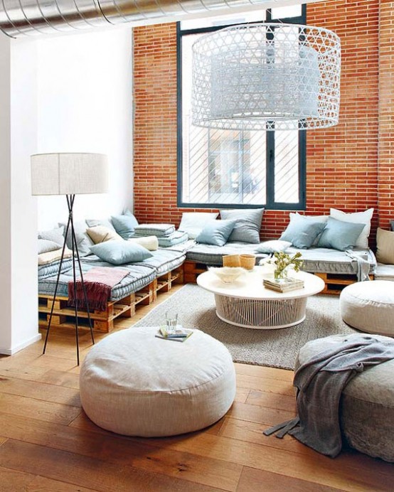 an eclectic living room with bright orange brick walls and contrasting blue furniture and large lampshades