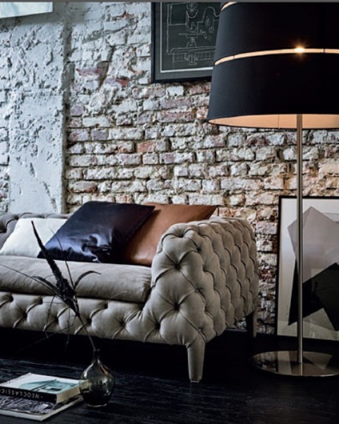 a luxurious and refined living room in black and white with a rough brick statement wall