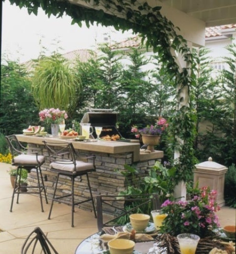 a traditional grill zone with a large kitchen island with a grill, a countertop for cooking and a raised meal space with stools