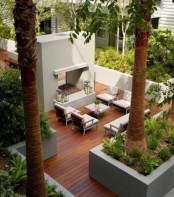 a contemporary deck with a concrete bar and several contemporary chairs plus greenery in flower beds around