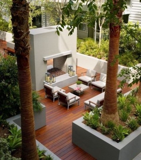 a contemporary deck with a concrete bar and several contemporary chairs plus greenery in flower beds around