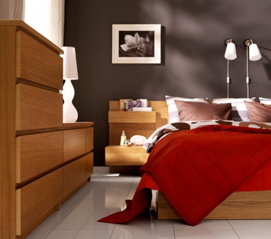 a chic modern bedroom with a graphite grey accent wall, stained furniture, contrasting bedding, artwork and wall sconces