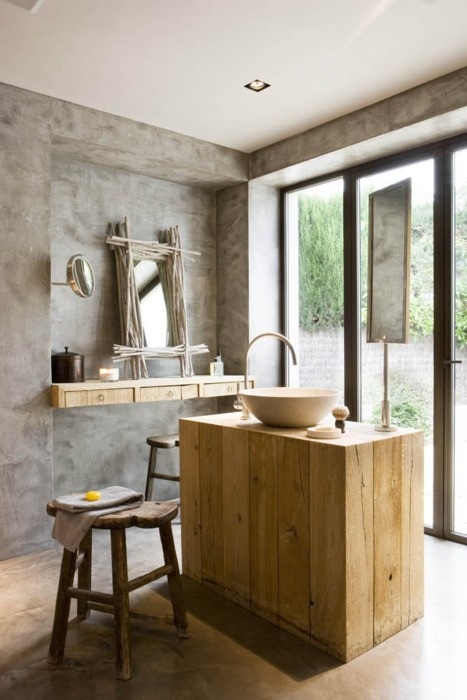 a minimalist bathroom of concrete and light-colored wood, the wood brings a cozy feel
