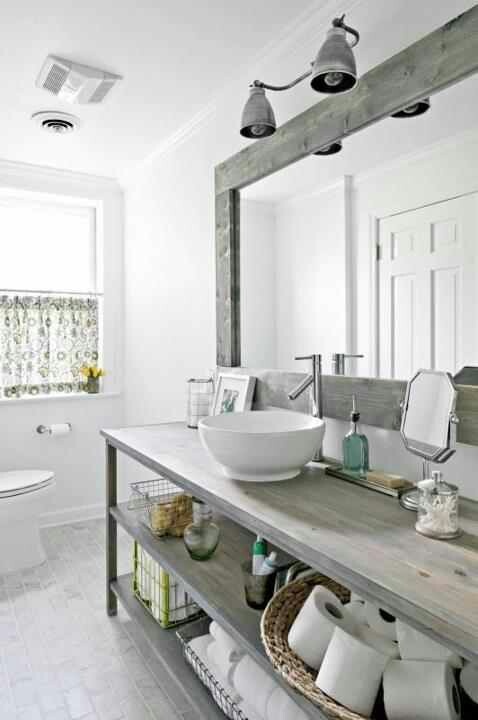 an airy farmhouse bathroom with white walls, a tiled floor and shabby chic wood touches