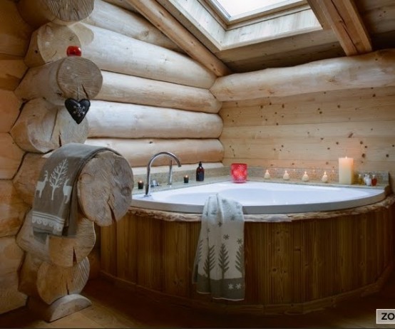 a rustic bathroom with much light-colored wood and a wood clad bathtub plus a skylight