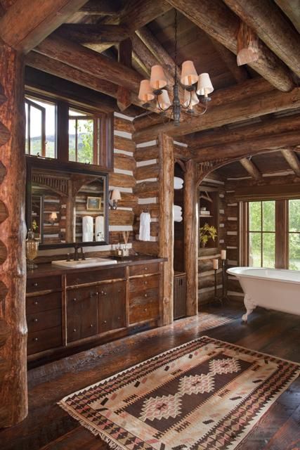 a rustic bathroom with much redwood and a chandelier plus some boho chic rugs