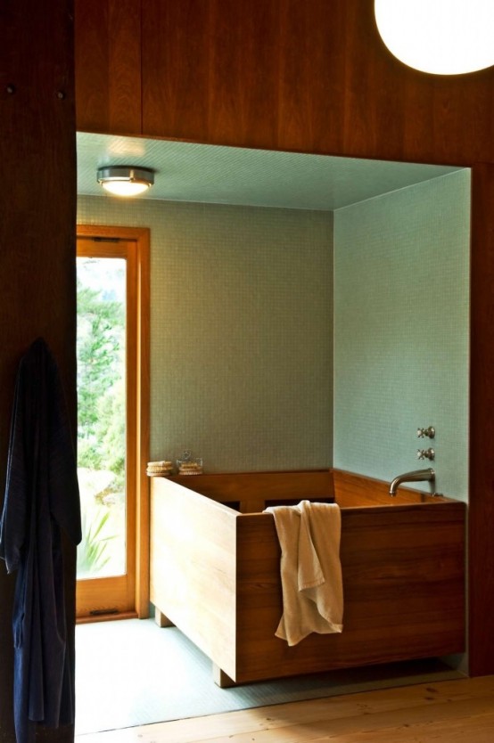 a contemporary bathroom with green tiles and a wooden square bathtub