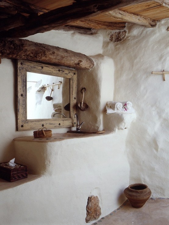 a rustic and wabi-sabi bathroom with white walls and much wood and driftwood