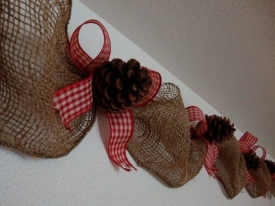 a burlap garland with pinecones and red plaid bows is a stylish Christmas idea with a rustic feel