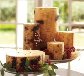 candles wrapped with wood bark and placed on plates to form cool rustic Christmas centerpieces or decorations