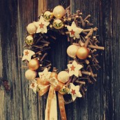 a rustic Christmas wreath of sticks, pretty metallic ornaments, stars and printed ribbons
