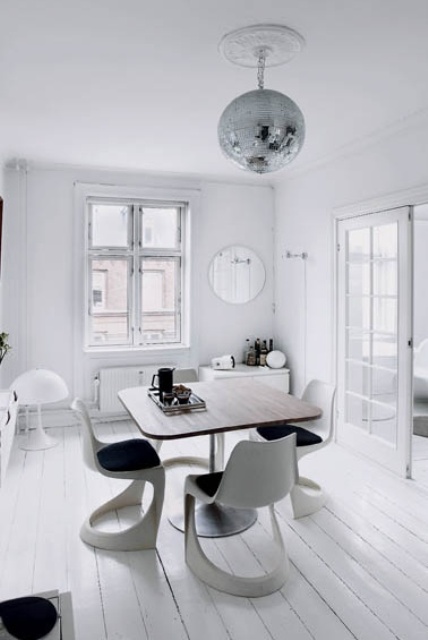 an airy Scandinavian dining room with a square rounded corner table, white sculptural chairs and a disco ball is a unique solution to try