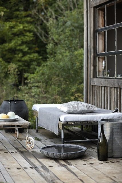 a Nordic porch with shabby chic metal daybeds, a concrete bowl, a metal bucket and some neutral bedding