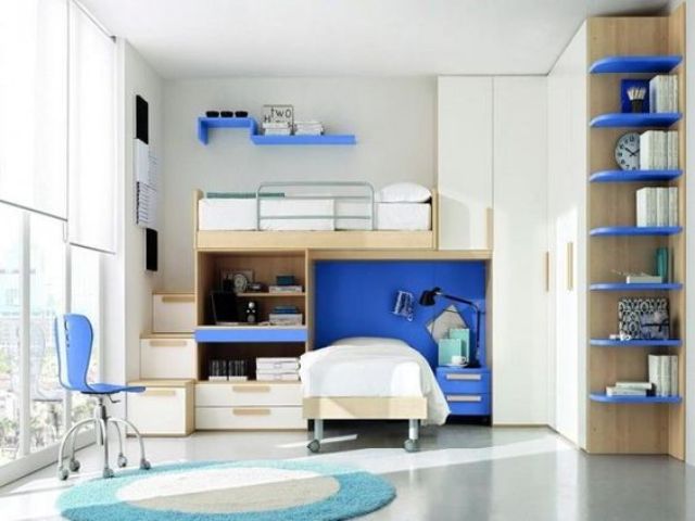 a bold modern teen shared bedroom with white walls and furniture, a glazed wall, bright blue touches and plenty of storage space