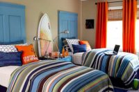 a bright surfing teen boy bedroom with door headboards, surfs, colorful textiles and bedding